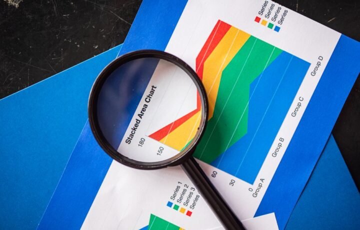Magnifying glass highlighting stacked area charts for business analysis.