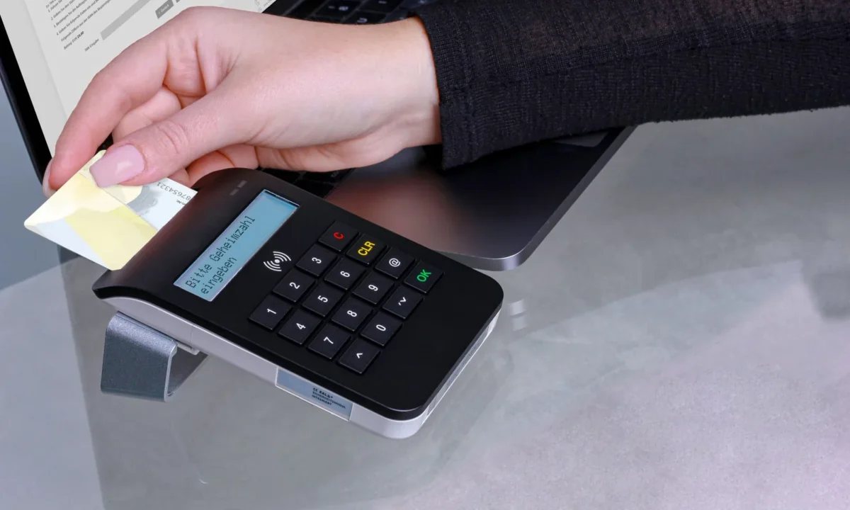 Mão inserindo cartão em terminal de pagamento contactless para transação segura via API pagamento subadquirente